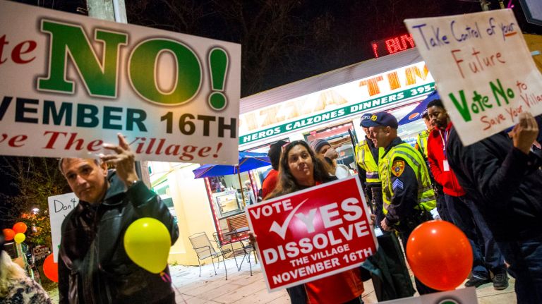 Residents hold up signs regarding village vote